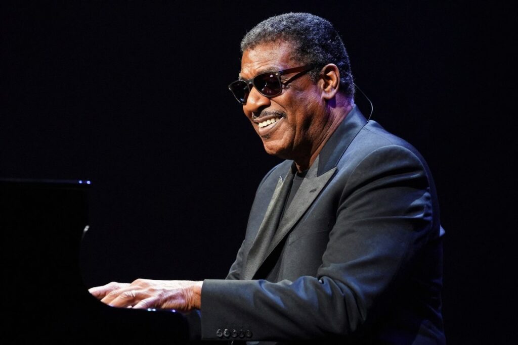 Ray Charles, sławny niewidomy muzyk, grający na fortepianie z charakterystycznym uśmiechem